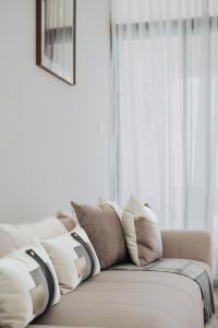un sofá con almohadas y ventana en Waves and Whispers -by Hestia Living, en Mombasa
