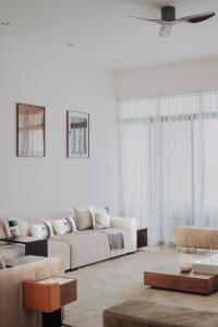 Una sala de estar blanca con un sofá y una mesa. en Waves and Whispers -by Hestia Living, en Mombasa