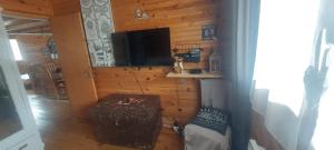 a room with a wall with a television and a table at Logement cosy au pied des pistes in Saint-Pierre-dels-Forcats