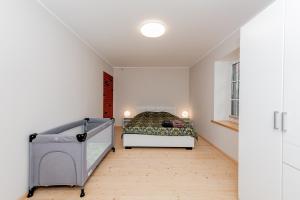 a bedroom with a bed in a white room at Vingi Familyhouse with free parking and sauna in Pärnu
