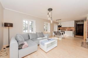 a white living room with a white couch and a table at Vingi Familyhouse with free parking and sauna in Pärnu