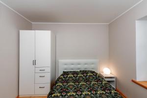 a bedroom with a bed and a white cabinet at Vingi Familyhouse with free parking and sauna in Pärnu +19 photos