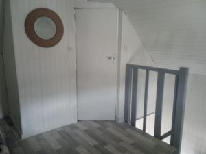 a stairway with a door and a mirror on the wall at Petit studio sud gare in Rennes