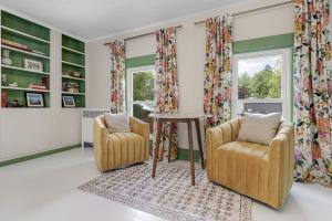 a living room with two chairs and a table at GAGE FARMHOUSE LIMIT 6 apts in Bridgton