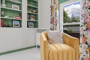 a yellow chair in a room with a window at GAGE FARMHOUSE LIMIT 6 apts in Bridgton +19 photos