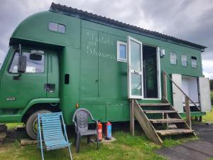 a green truck parked with a house on it at Courtlands farm camping and glamping in Canterbury