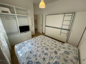 a bedroom with a bed and a television in it at Appartamento Celeste piazza Mazzini Spiaggia in Lido di Jesolo