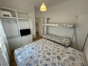 a bedroom with two bunk beds and a television at Appartamento Celeste piazza Mazzini Spiaggia in Lido di Jesolo