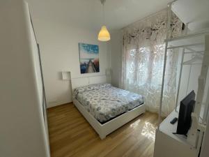 a bedroom with a bed and a window and a television at Appartamento Celeste piazza Mazzini Spiaggia in Lido di Jesolo