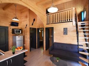 a living room with a blue couch and a staircase at Camping des Gaves in Laruns