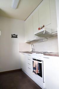 une cuisine blanche avec un évier et une cuisinière dans l'établissement Rovaniemi City Centre Apartments, à Rovaniemi