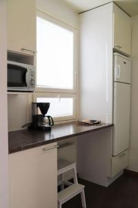 une cuisine avec un comptoir, un four micro-ondes et une fenêtre dans l'établissement Rovaniemi City Centre Apartments, à Rovaniemi 13 autres photos