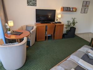 TV a/nebo společenská místnost v ubytování Apartment mit Balkon und Pool, zentral am Waldrand