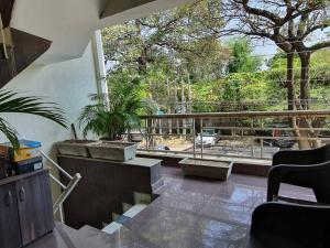 a room with stairs and a balcony with plants at Comfy 3BHK house with Cinema like Home Theatre ! in Sohāna
