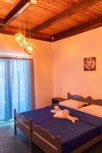 a bedroom with two beds with blue sheets and a wooden ceiling at HOTEL KM 0 in Costinesti +115 photos