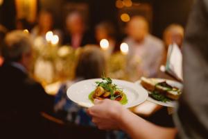 a person holding a plate of food in a restaurant at The Brisley Bell in Brisley
