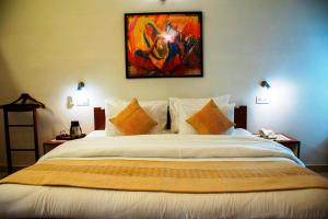 1 dormitorio con 1 cama grande y una pintura en la pared en Girisadan Boutique Hotel en Jaipur