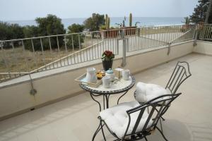 a table and chairs on a balcony with a view of the ocean at Il Sestante B&B in Condofuri