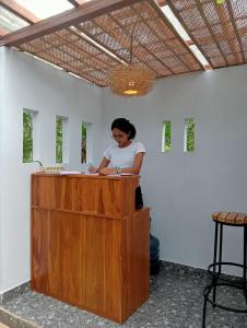 a woman standing at a wooden counter in a room at Gladak di Uma Bali in Sidemen
