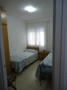 a bedroom with two beds and a window at brisa mar in San Pol de Mar