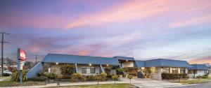 蒂默特Amaroo Motel Tumuts Best Accommodation的停车场内有蓝色屋顶的建筑
