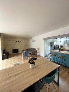 a living room with a wooden table and a kitchen at Magnifique Maison de Ville in Lormont