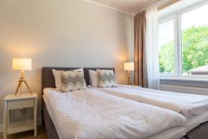 a large bed in a bedroom with a large window at Parkside Central Apartment by Kuus Sõlme in Kuressaare