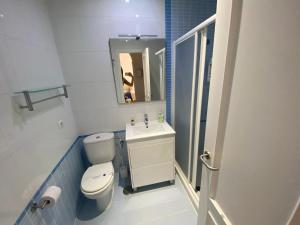 a bathroom with a toilet and a sink and a mirror at Apartamento Centro Chipiona La Perla in Chipiona +1 photo