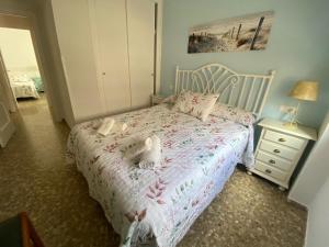 a bedroom with a bed with two dolls on it at Apartamento Centro Chipiona La Perla in Chipiona