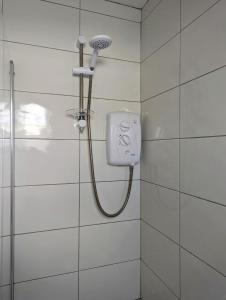 a shower in a bathroom with a shower head at Sunny Cottage in Wexford +5 photos