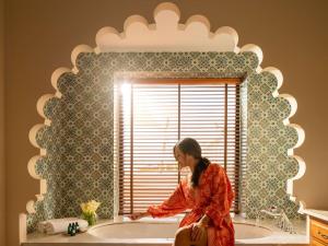 a woman sitting in front of a bathroom mirror at Sofitel Bahrain Zallaq Thalassa Sea & Spa in Manama