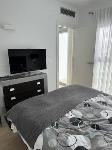a bedroom with a tv and a bed with a blanket at Luxury Villa Torrevieja With Swimmingpool in Torrevieja