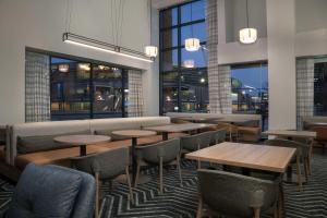 a restaurant with tables and chairs and windows at Homewood Suites by Hilton Omaha - Downtown in Omaha