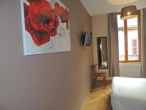 ル・ブール・ドアザンにあるHotel Des Alpesの赤い花の絵が壁に描かれたベッドルーム