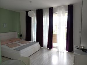 a bedroom with a white bed and a large window at Ana Rooms in Krk