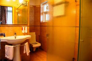 a bathroom with a sink and a toilet and a mirror at Girisadan Boutique Hotel in Jaipur