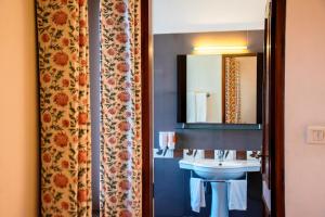 W łazience znajduje się umywalka i lustro. w obiekcie Girisadan Boutique Hotel w mieście Dżajpur