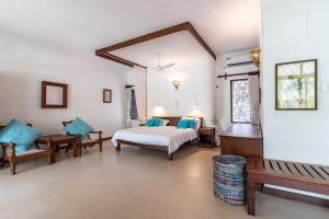 a hotel room with a bed and a bench at Watano Beach House Diani in Diani Beach +53 photos