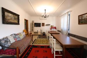 un soggiorno con divano, tavolo e sala da pranzo di Baza Hostel - Swimming Pool a Berat