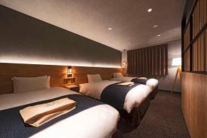 高山市にあるhotel around TAKAYAMA, Ascend Hotel Collectionのベッド2台とテレビが備わるホテルルームです。