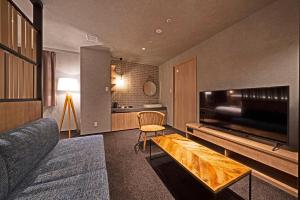 高山市にあるhotel around TAKAYAMA, Ascend Hotel Collectionのリビングルーム(ソファ、大画面テレビ付)