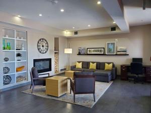 uma sala de estar com um sofá e uma televisão em Country Inn & Suites by Radisson, Tucson Airport, AZ em Tucson