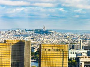 vista su una città con un edificio giallo di Too Hotel Paris - MGallery a Parigi