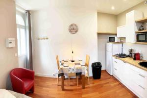 a kitchen with a table and chairs in a room at Studio TOURNETTE in Chambéry