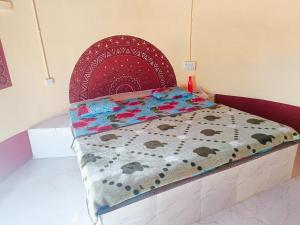 a bedroom with a bed with a red head board at Rann Kutch Resort in Dhordo