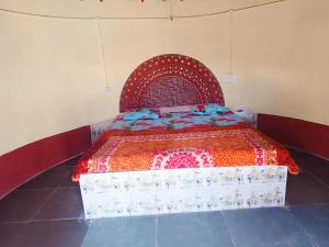 a bed in a room with a red and white bedspread at Rann Kutch Resort in Dhordo