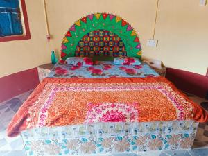 a large bed with a colorful bedspread on it at Rann Kutch Resort in Dhordo
