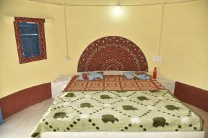 a bed with a wooden headboard in a room at Rann Kutch Resort in Dhordo