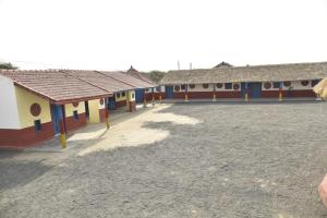 a row of colorful buildings in a field at Rann Kutch Resort in Dhordo