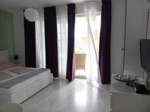 a bedroom with a white bed and a large window at Ana Rooms in Krk